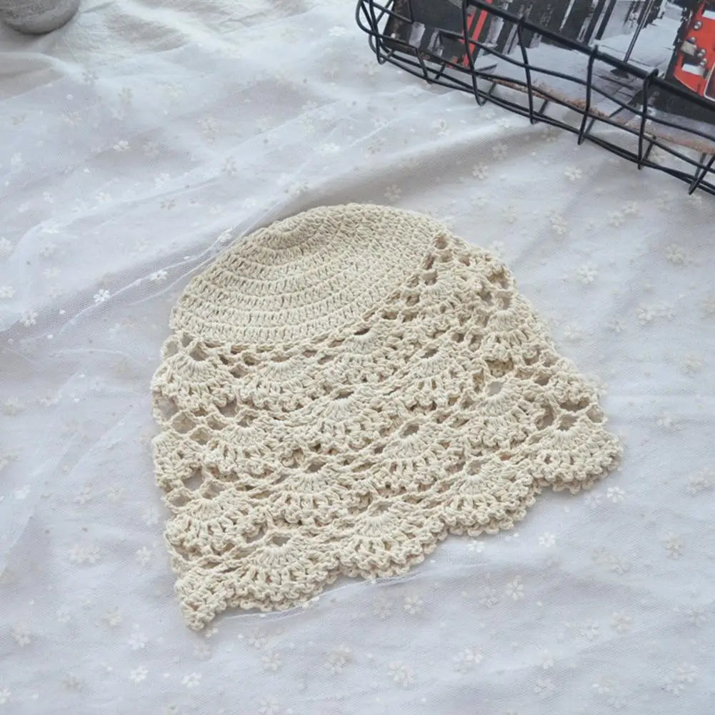 Cream-coloured women’s crochet hat featuring an intricate hollow lace pattern with a scalloped edge.