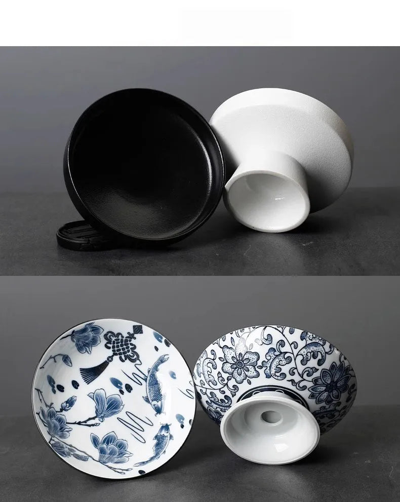 Set of two pedestal tea bowls, one with black and white matte finish, one with blue and white floral koi pattern.