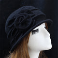 Elegant black wool winter hat on a mannequin, featuring a side rosette detail and a small brim.