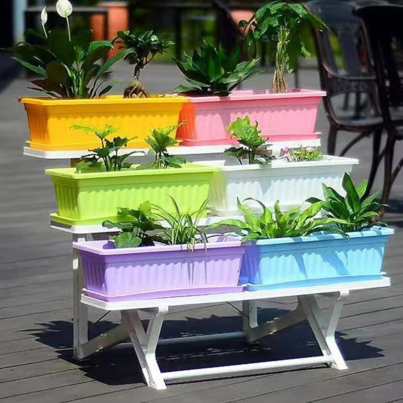 Colorful rectangular plastic planters in yellow, pink, lime, white, purple, and blue, displayed on a white tiered stand.