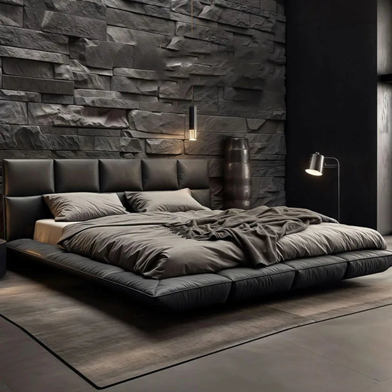 Modern charcoal leather king-size floating bed with a structured headboard, set against a dark textured stone wall.