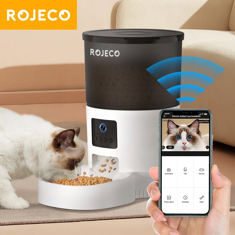 Smart white and black automatic pet feeder with camera, displaying real-time video on a smartphone app.