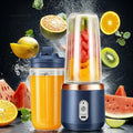 Portable blue and copper electric blender with a clear cup filled with chopped fruit, set against floating fruit.