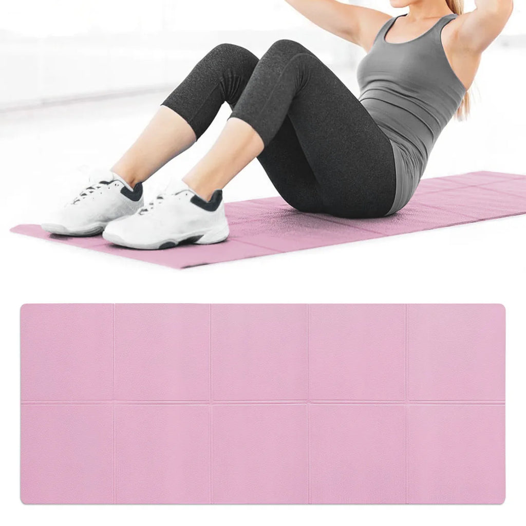A foldable pink exercise mat with a textured surface, shown in use by a person doing sit-ups.