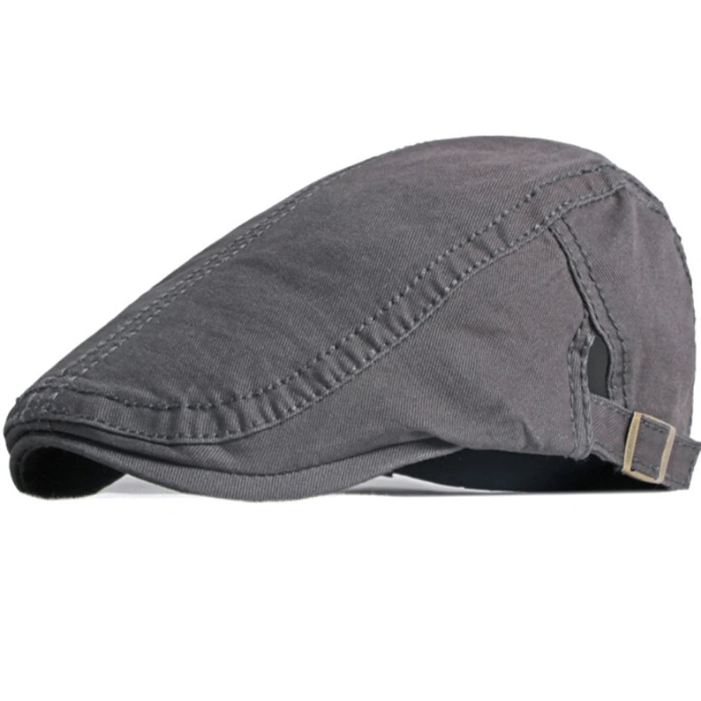 Unisex grey cotton flat cap with stitched panel detailing and an adjustable metal buckle strap at the side.