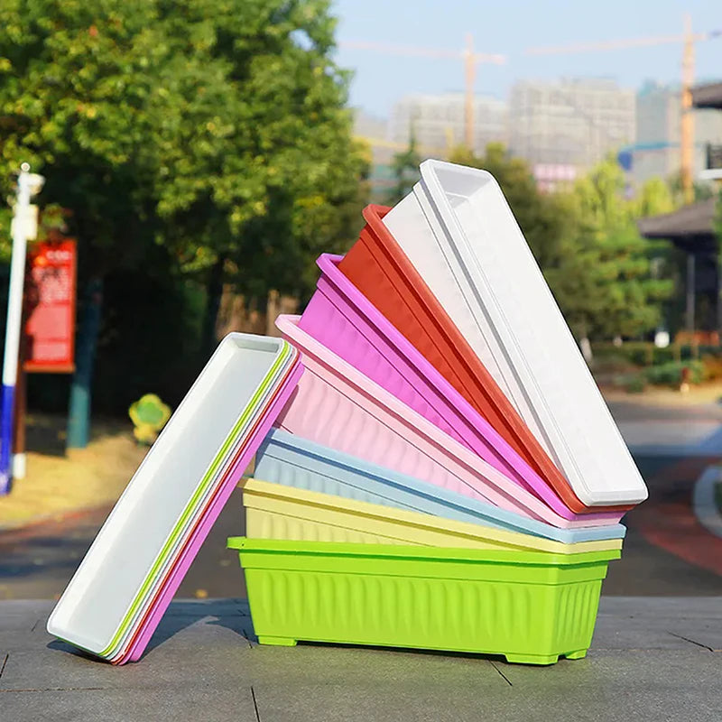 A stack of colorful, rectangular plastic vegetable planters in green, yellow, blue, pink, red, and white.