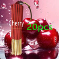 Bundle of 20 red cherry-scented incense sticks against a background of fresh red cherries.