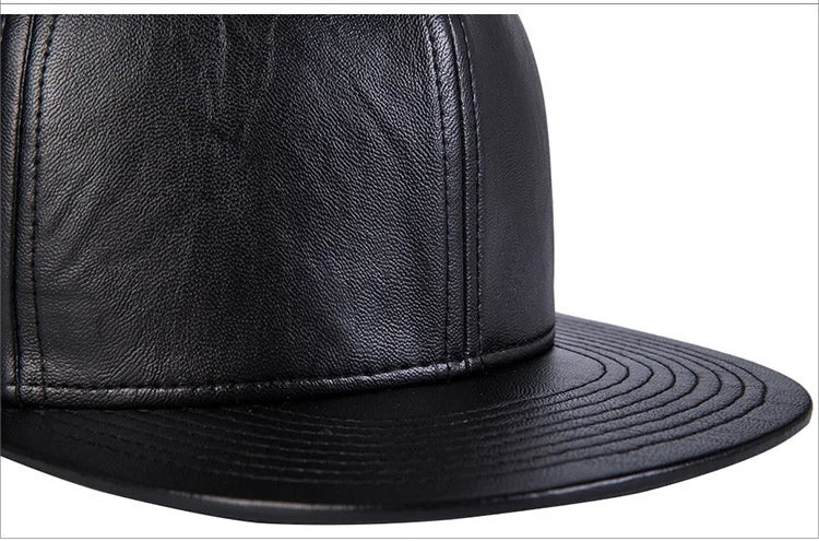 Close-up of a men's black leather baseball cap featuring a structured crown and a stitched flat brim.