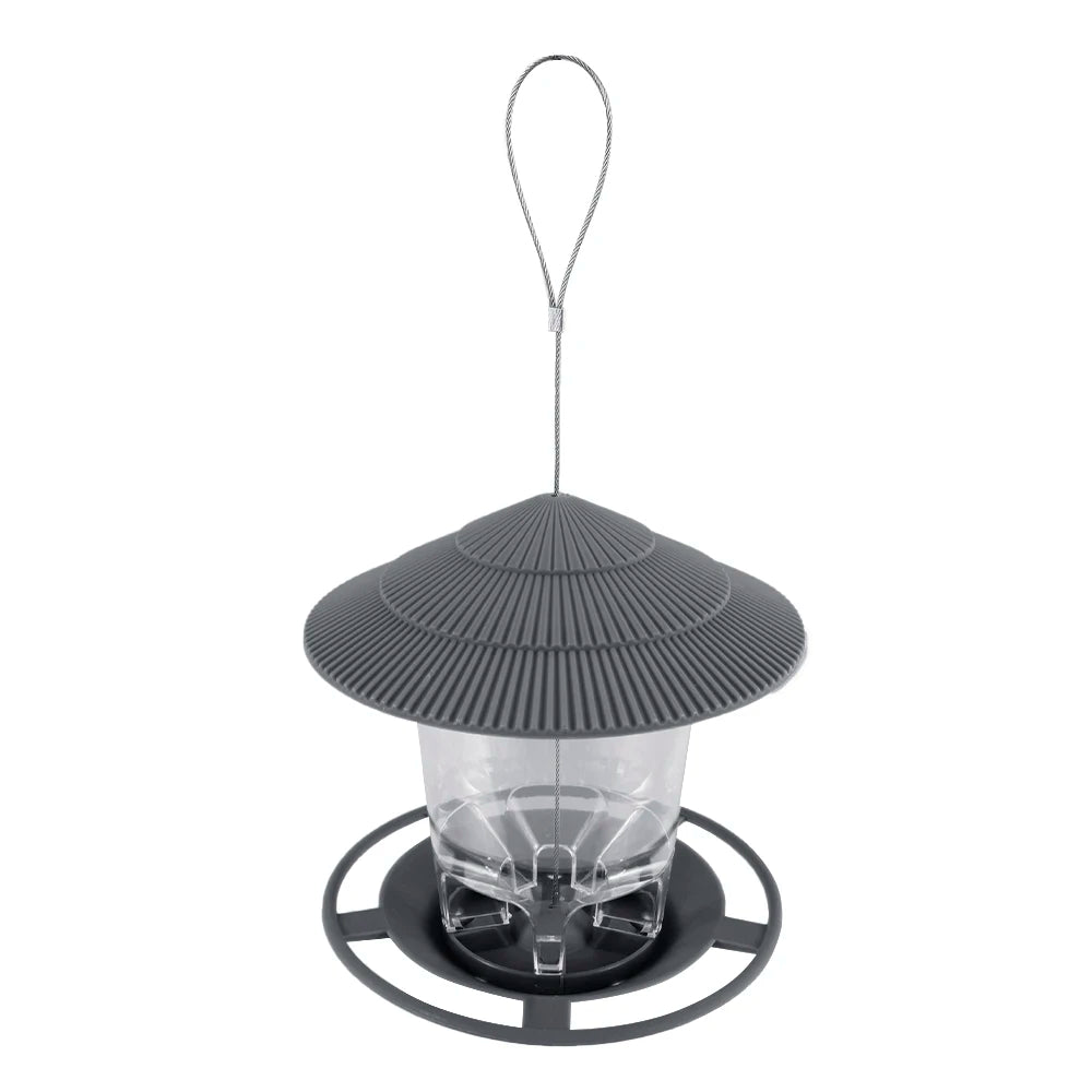 Grey hanging bird feeder with a ridged roof, clear reservoir, and circular feeding tray. Isolated on white background.