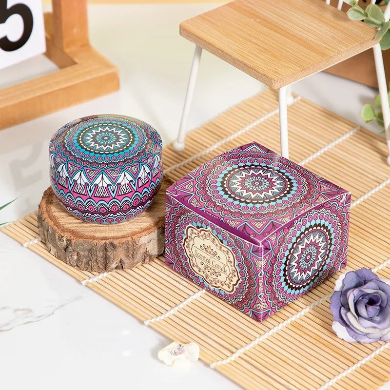 Scented candle in a round, colourful mandala-patterned tin with a matching square presentation box.