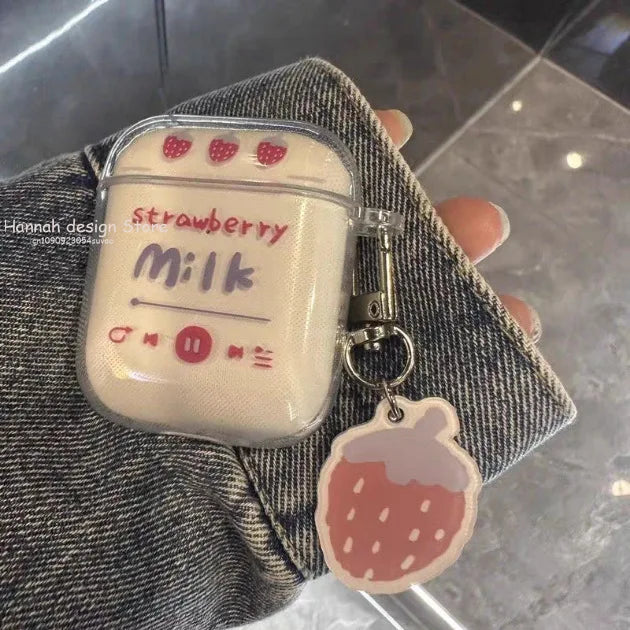 Clear AirPods case with "Strawberry Milk" print, music player design, and strawberry charm. Fits standard AirPods.