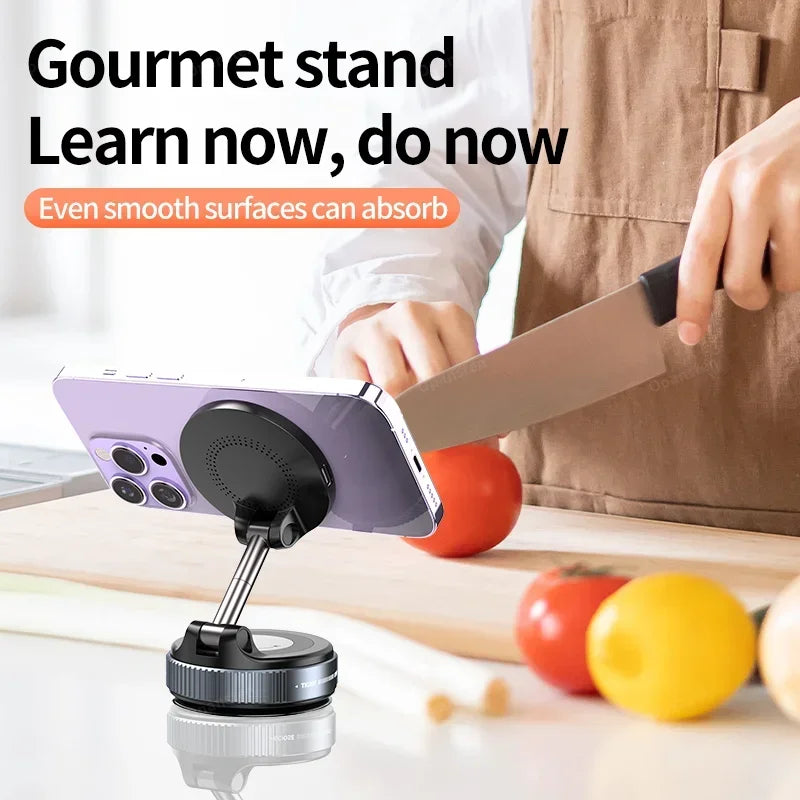 Black magnetic phone stand with adjustable arm and suction base, attached to a surface near a person cooking.