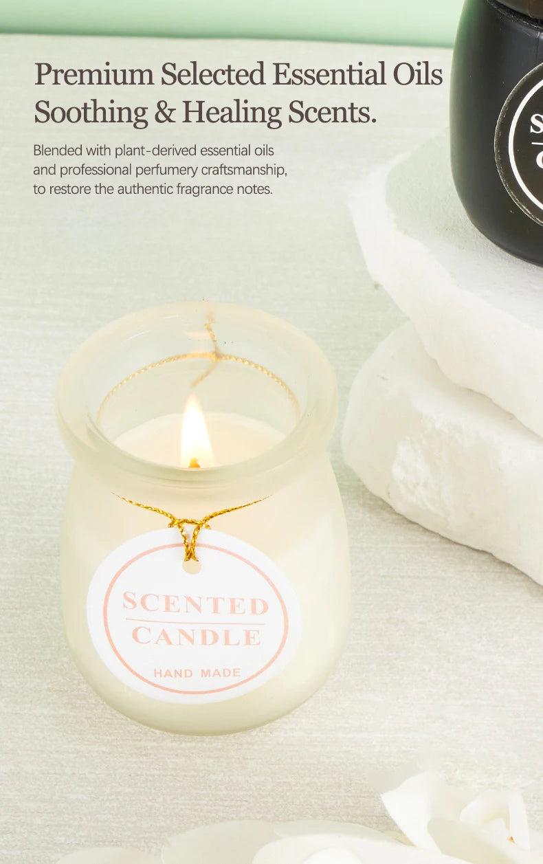 Lit scented candle in a frosted glass jar with a decorative hanging tag, set on a stone surface.