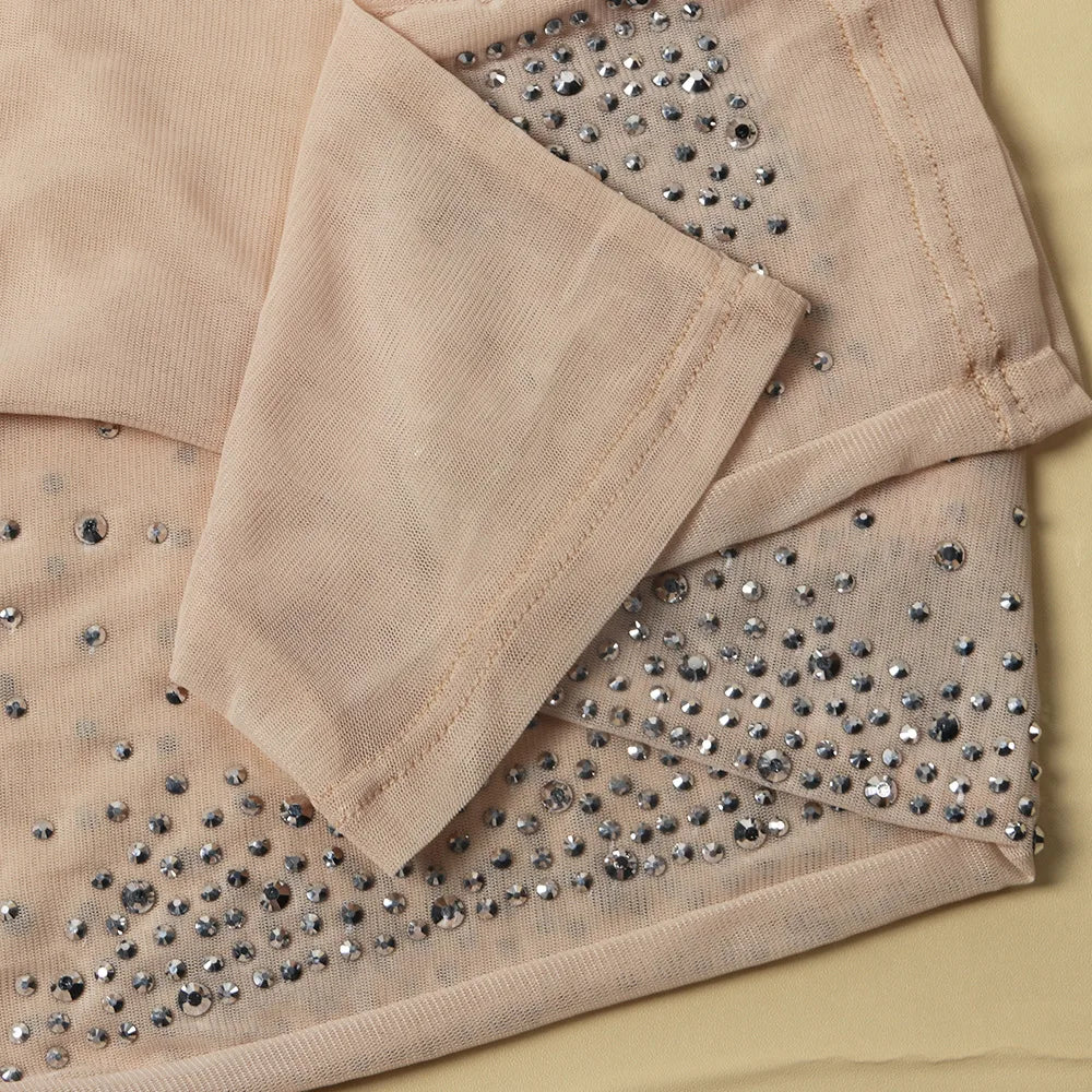 Nude sheer mesh jumpsuit fabric adorned with sparkling silver rhinestones.