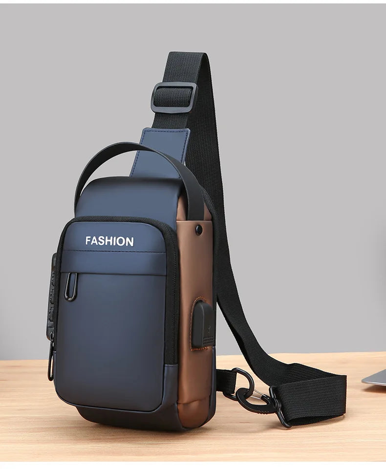 Navy blue and brown crossbody sling bag with a top handle, adjustable strap, and side USB charging port.