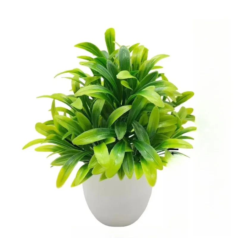 A small, vibrant artificial plant with variegated green leaves in a simple, rounded white plastic pot.