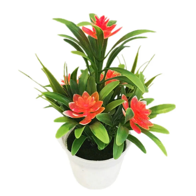 Artificial plant with vibrant red-orange star-shaped flowers and pointed green leaves in a small white plastic pot.