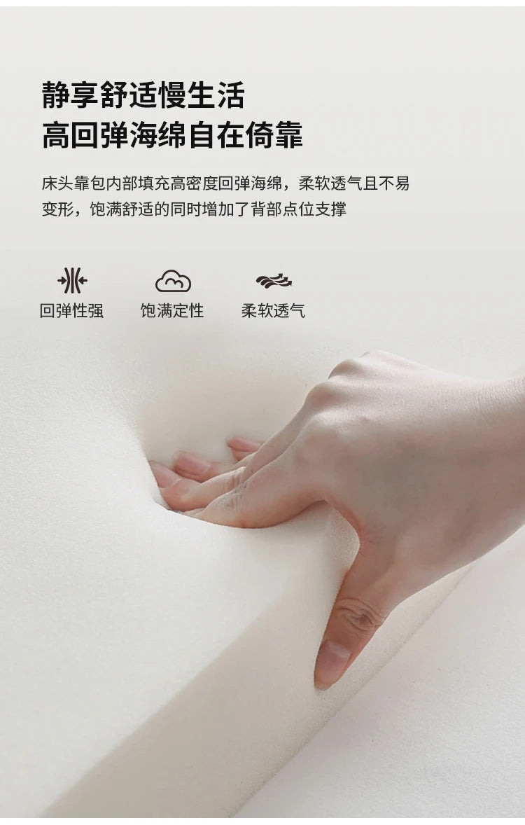 Close-up of a hand pressing into high-density, white memory foam padding for a luxury bed headboard.