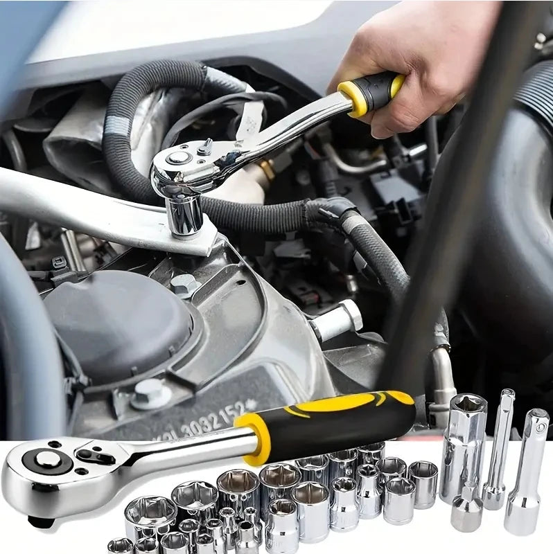 Chrome ratchet wrench with black and yellow handle used on car engine, alongside various metal sockets.