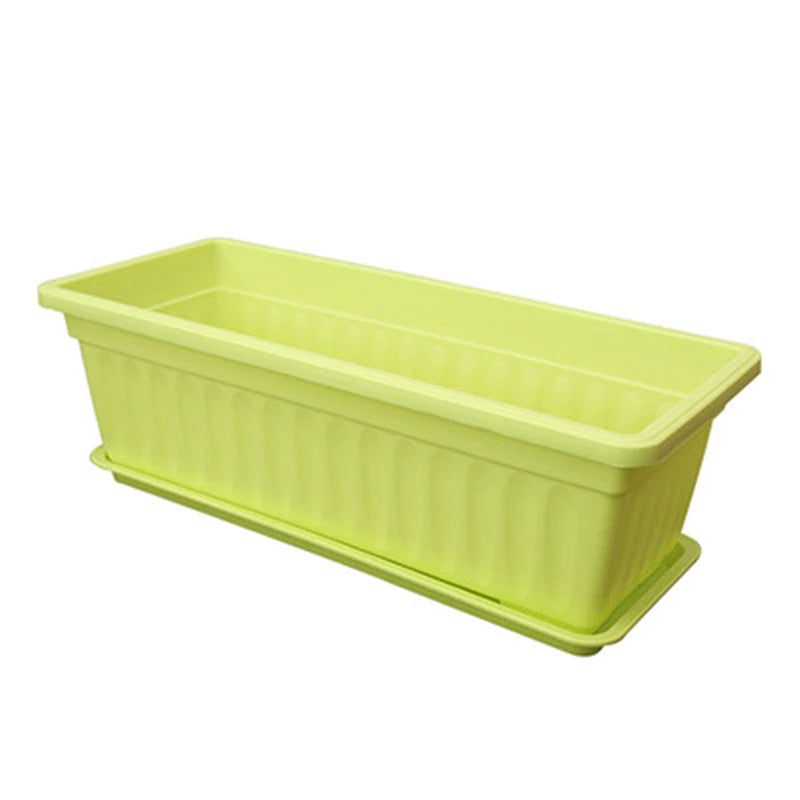 Light green rectangular plastic planter with vertical ribbed sides and a matching bottom drip tray against white.