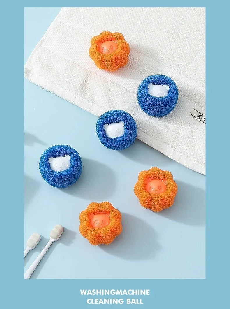 Orange and blue sponge laundry balls with cute bear faces, arranged on a blue surface with a white towel.
