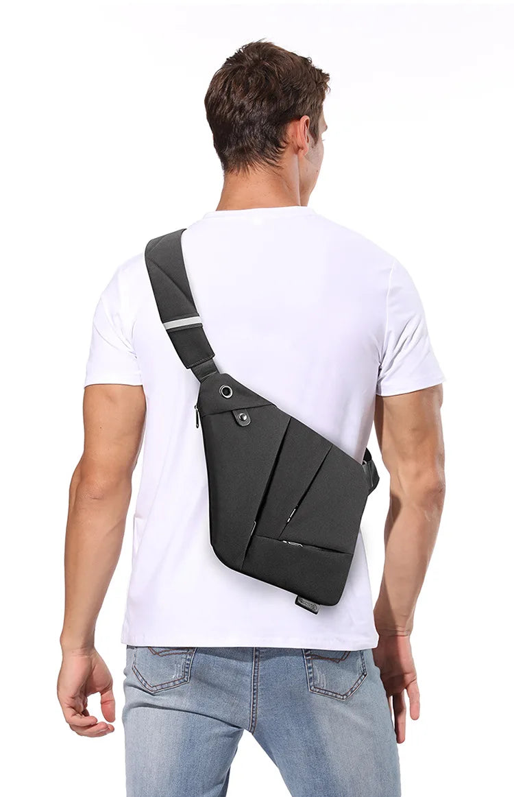 Man wearing a slim, black, waterproof anti-theft crossbody bag over a white t-shirt.