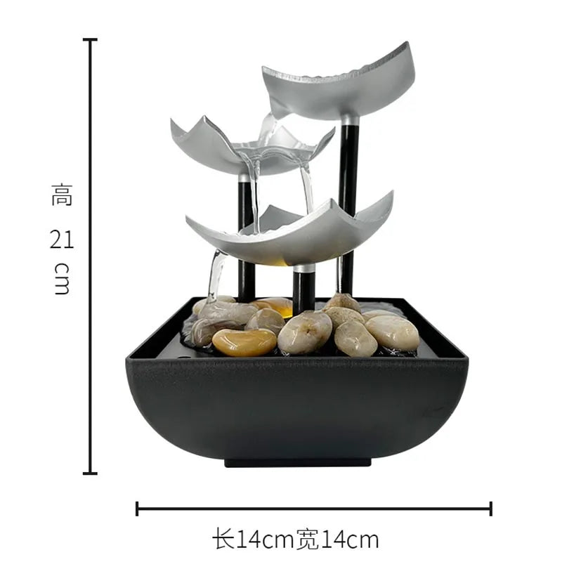 Modern tabletop water fountain with silver tiered bowls, black stand, and decorative river stones in a black base.