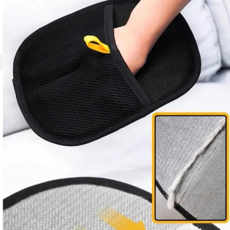 A hand wearing a black mesh cleaning mitt with a yellow hanging loop, showing a textured grey reverse side.
