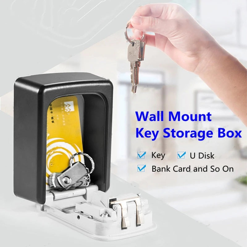 Black wall-mount key storage box with an open door, showing a card and keys inside. Hand holding keys above.