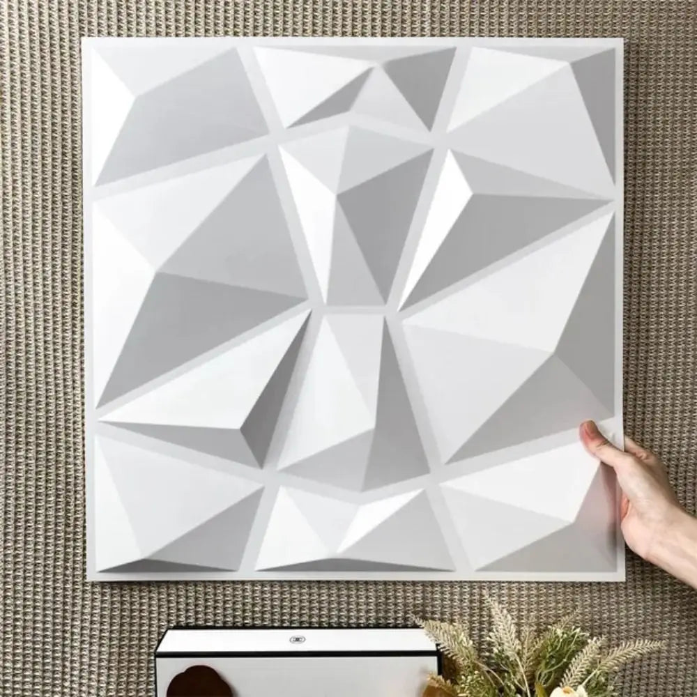White 3D decorative wall panel with a modern geometric diamond design, held against a textured background.