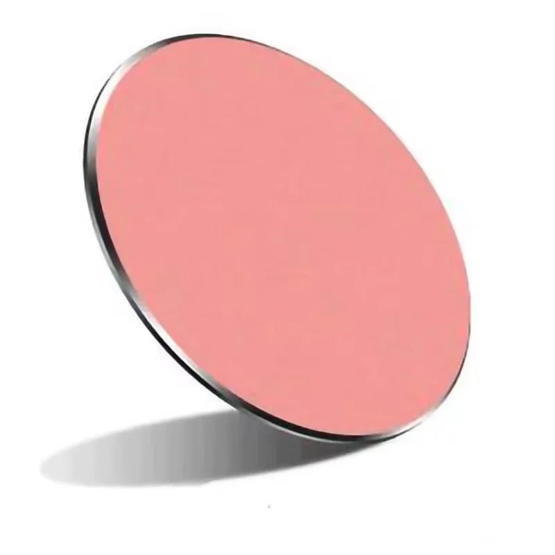 A round, thin, salmon-pink wireless charging pad with a sleek metallic edge, angled against a white background.