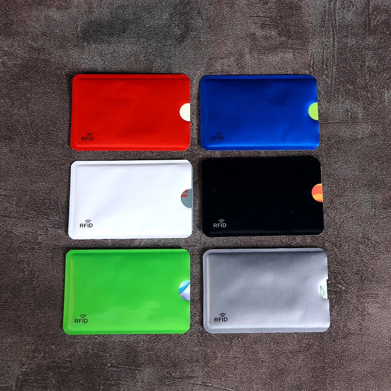 Six multicolored RFID-blocking plastic credit card sleeves arranged in two columns on a dark grey surface.