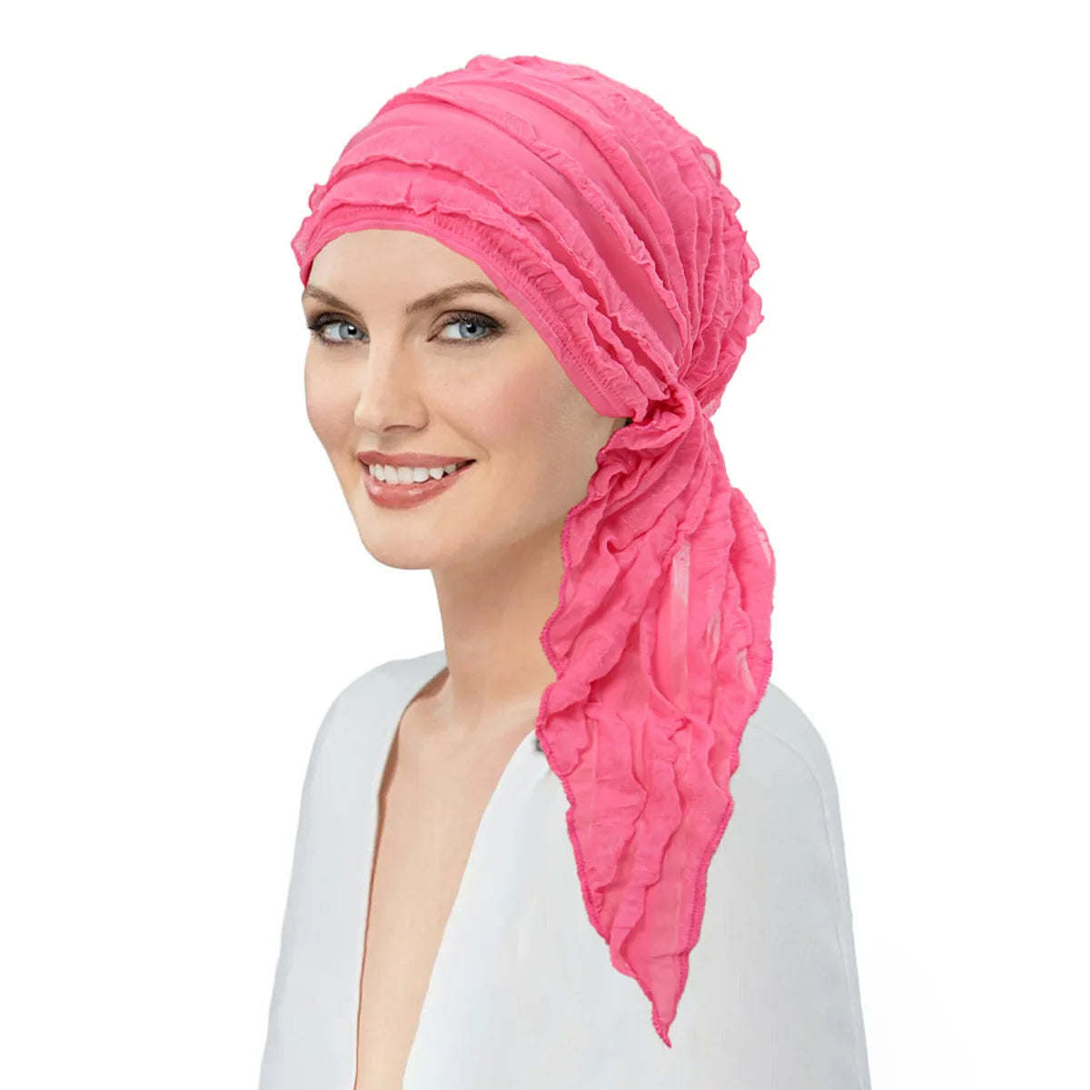 Woman wearing a vibrant pink, pre-tied elastic turban with a decorative ruffled side drape.