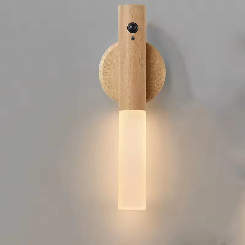 Minimalist wooden LED wall light with motion sensor, emitting a warm glow from a frosted glass cylinder.