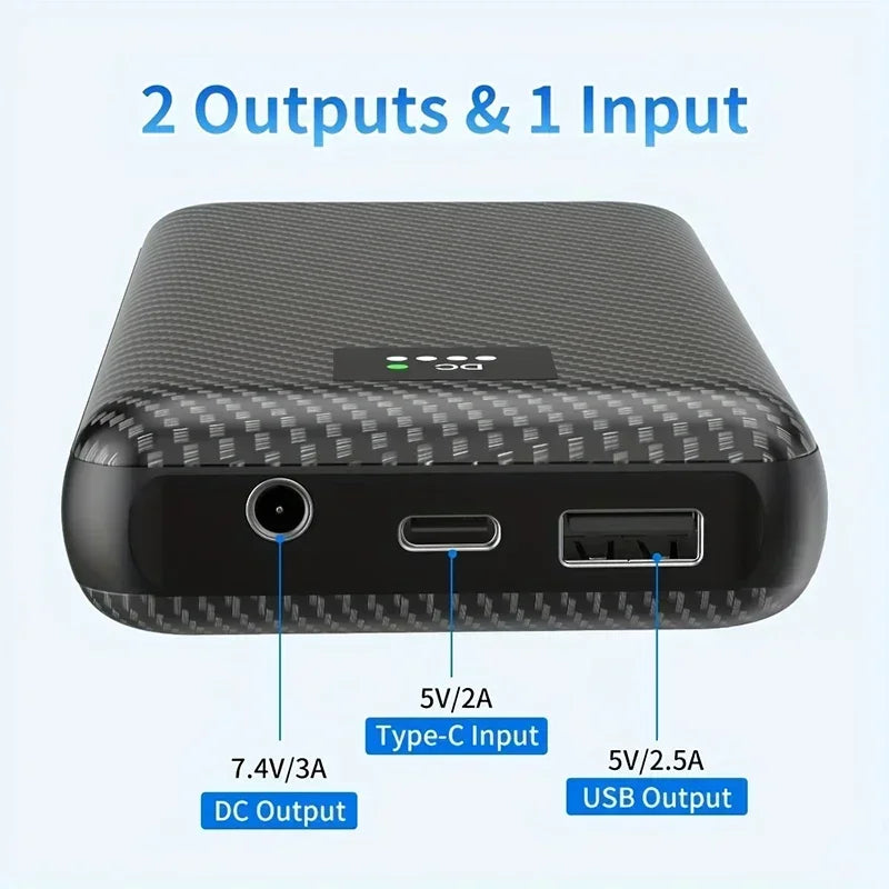 Black carbon-fibre finish portable power bank with DC, Type-C, and USB ports, plus a digital battery indicator.
