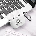 White silicone AirPods 3 case with black anime character graphic and carabiner, resting on a laptop.