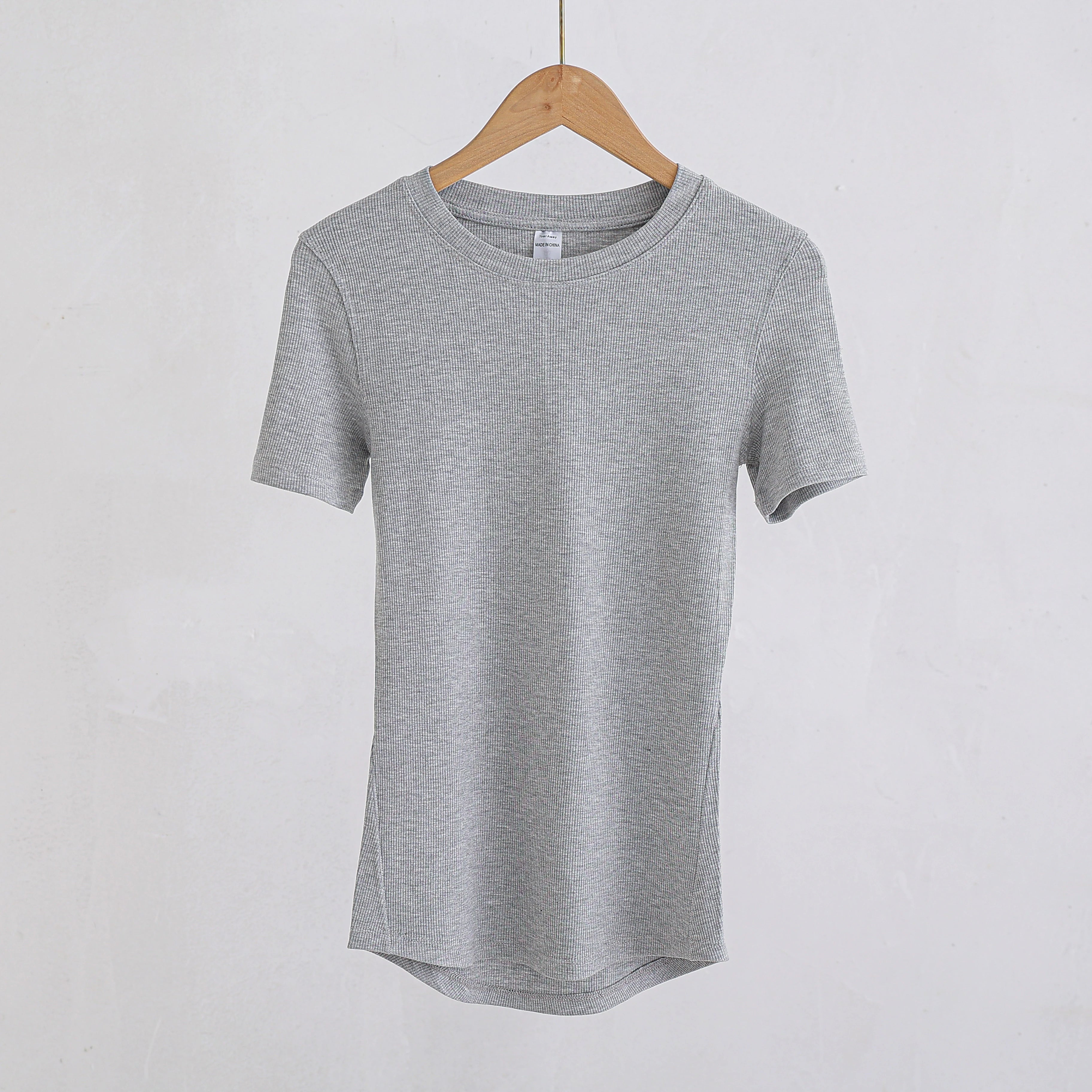 Grey ribbed crew-neck t-shirt with short sleeves and a curved hem, hanging on a wooden hanger.