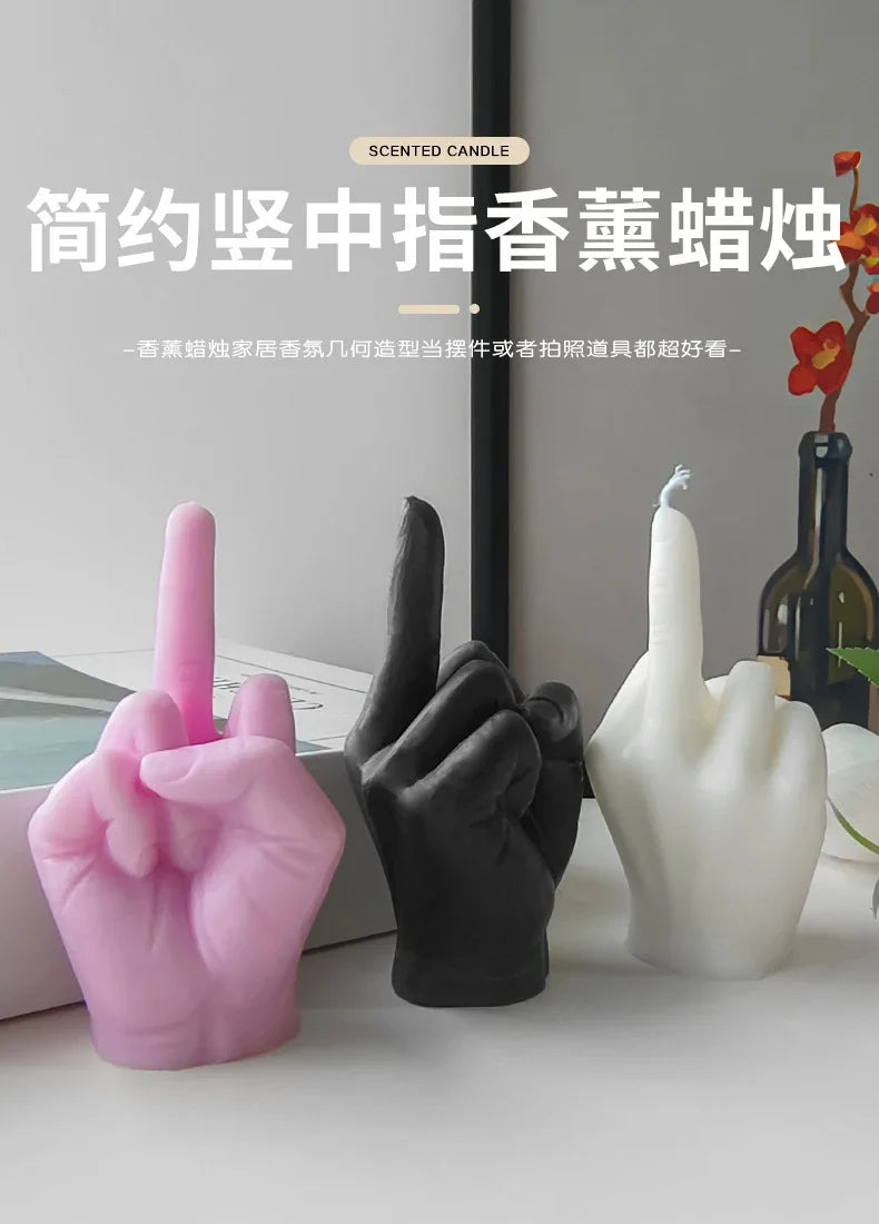 Three scented candles shaped like a middle-finger hand gesture in pink, black, and white.