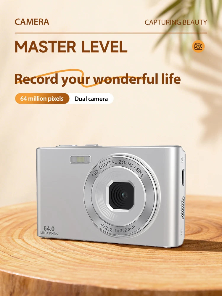 Silver digital camera with 64MP lens and 18x zoom, sitting on a wooden surface against a light background.