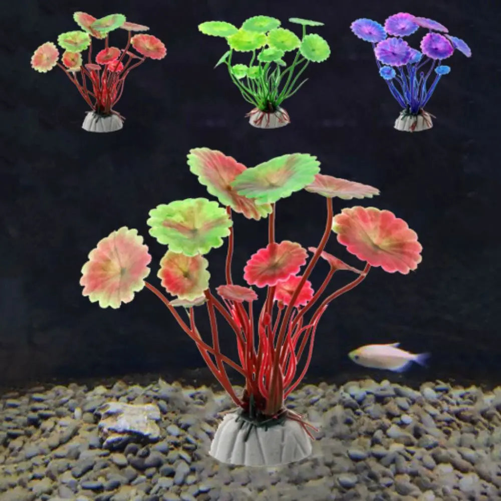 Artificial lily-pad aquarium plants in red/green, bright green, and purple, shown on a pebble tank floor.