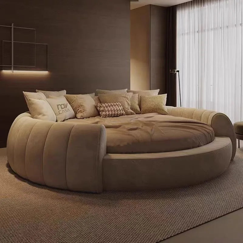 A contemporary round, upholstered bed in a soft beige tone, featuring a tufted design in a modern bedroom setting.
