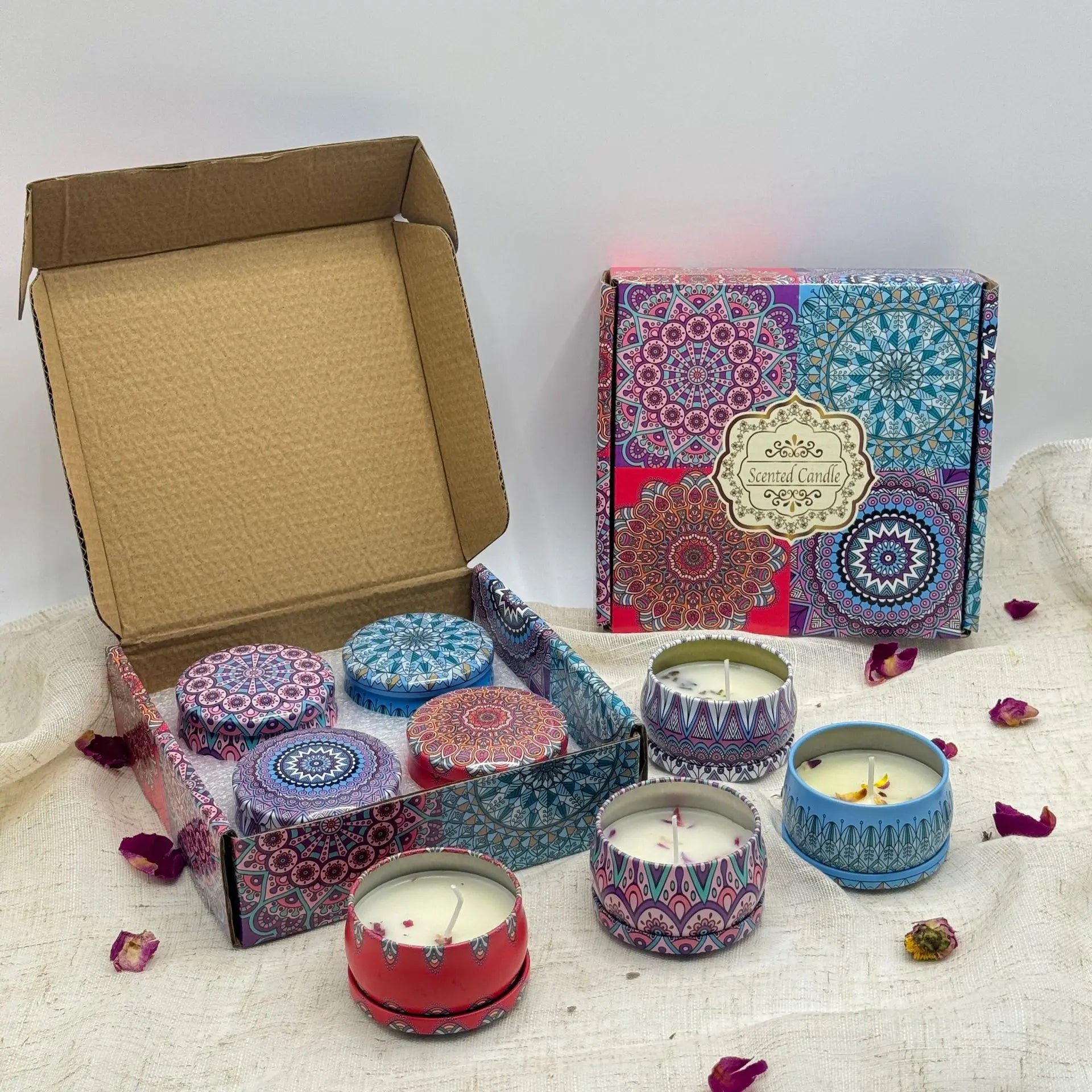Gift box set of three scented candles in vibrant, mandala-patterned colourful metal tins with lids.