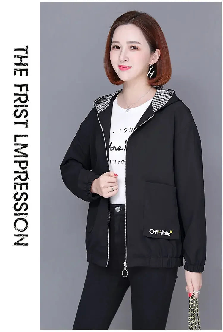 Woman wearing a black zip-up hooded jacket with a checkered inner lining, long sleeves, and front patch pockets.