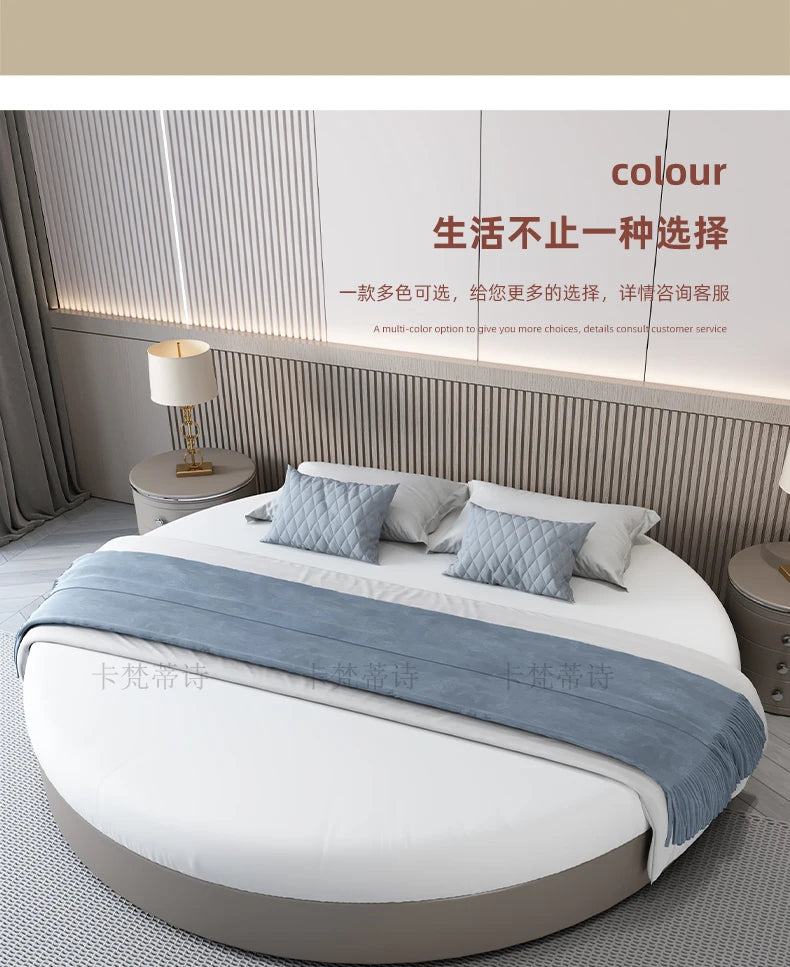 Modern minimalist round double bed frame in a soft grey finish, styled with white bedding and blue decorative cushions.