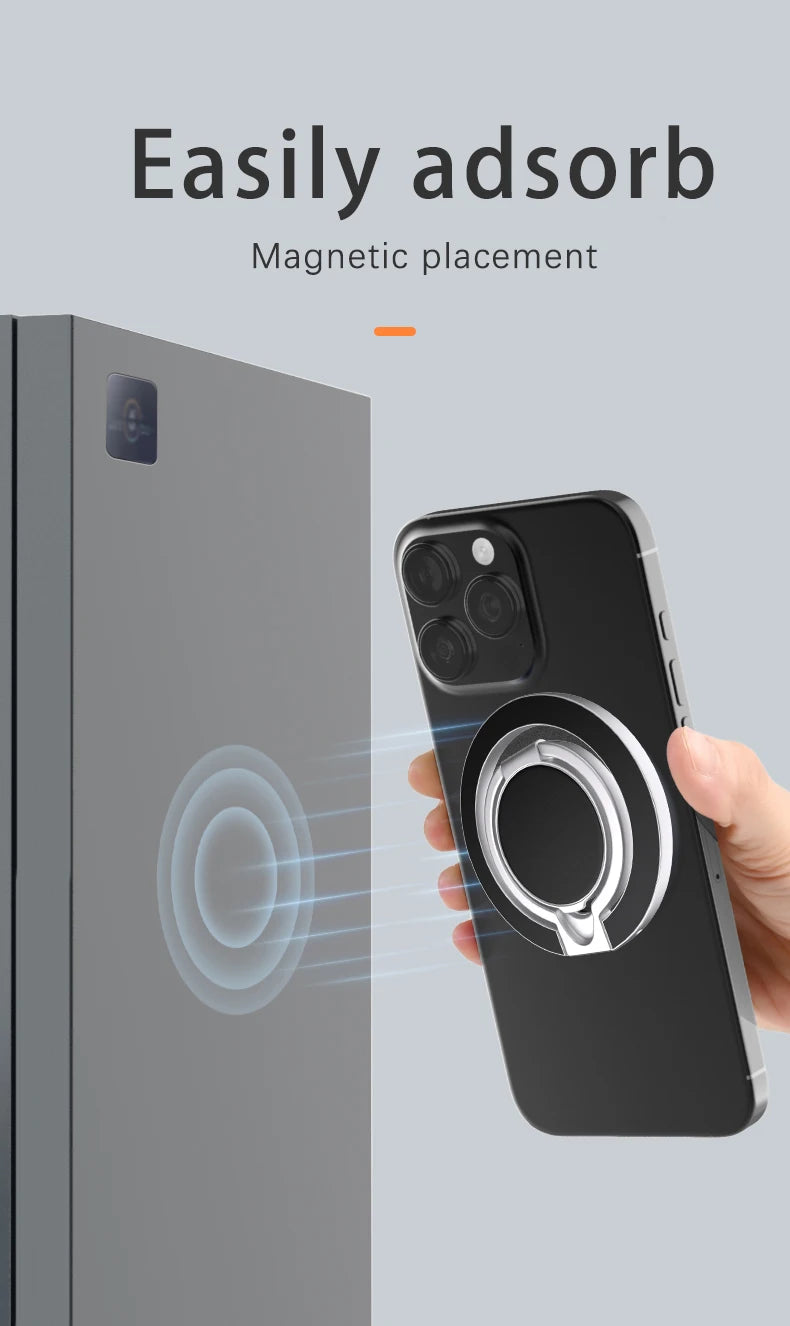 A hand holding a black smartphone with a round, silver magnetic ring holder attached to the back.