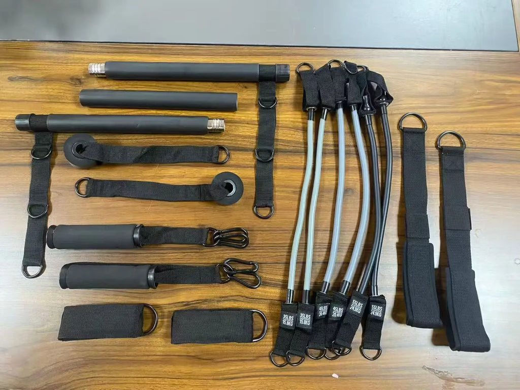 Complete black Pilates fitness kit including a detachable bar, resistance bands, handles, and ankle straps.
