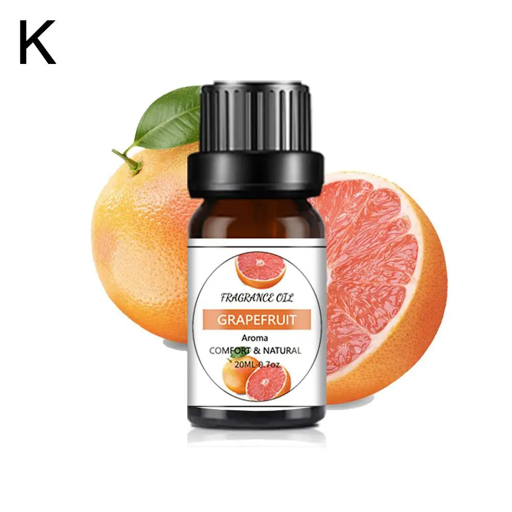 20ml brown glass bottle of grapefruit fragrance oil with black cap, set against fresh grapefruit segments.