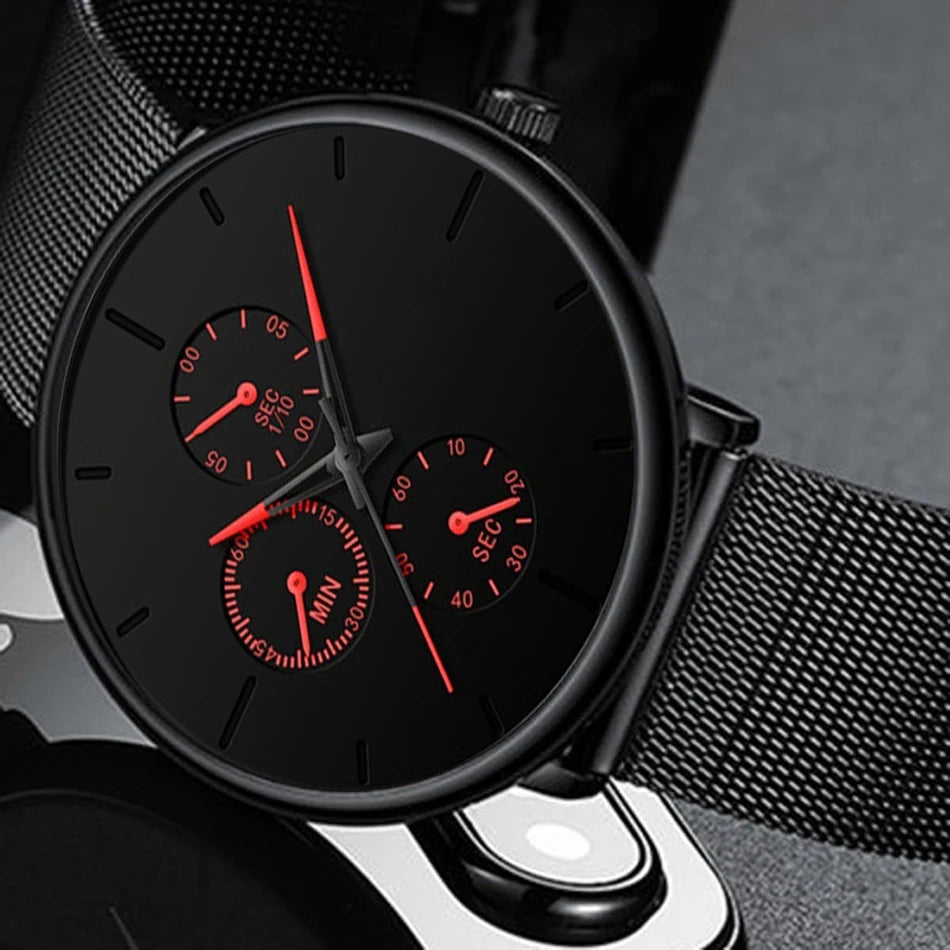 Ultra-thin men’s watch with a matte black dial, red accents, sub-dials and a black stainless steel mesh strap.