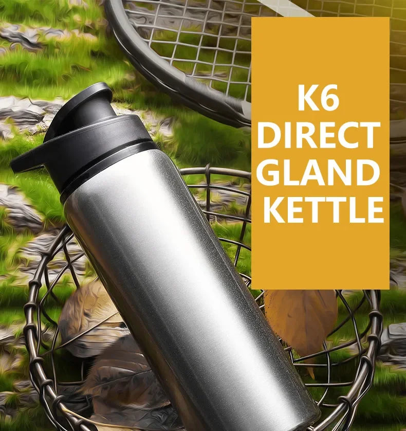 Silver stainless steel bottle with a black flip-top lid, positioned in a wire basket on a grassy background.