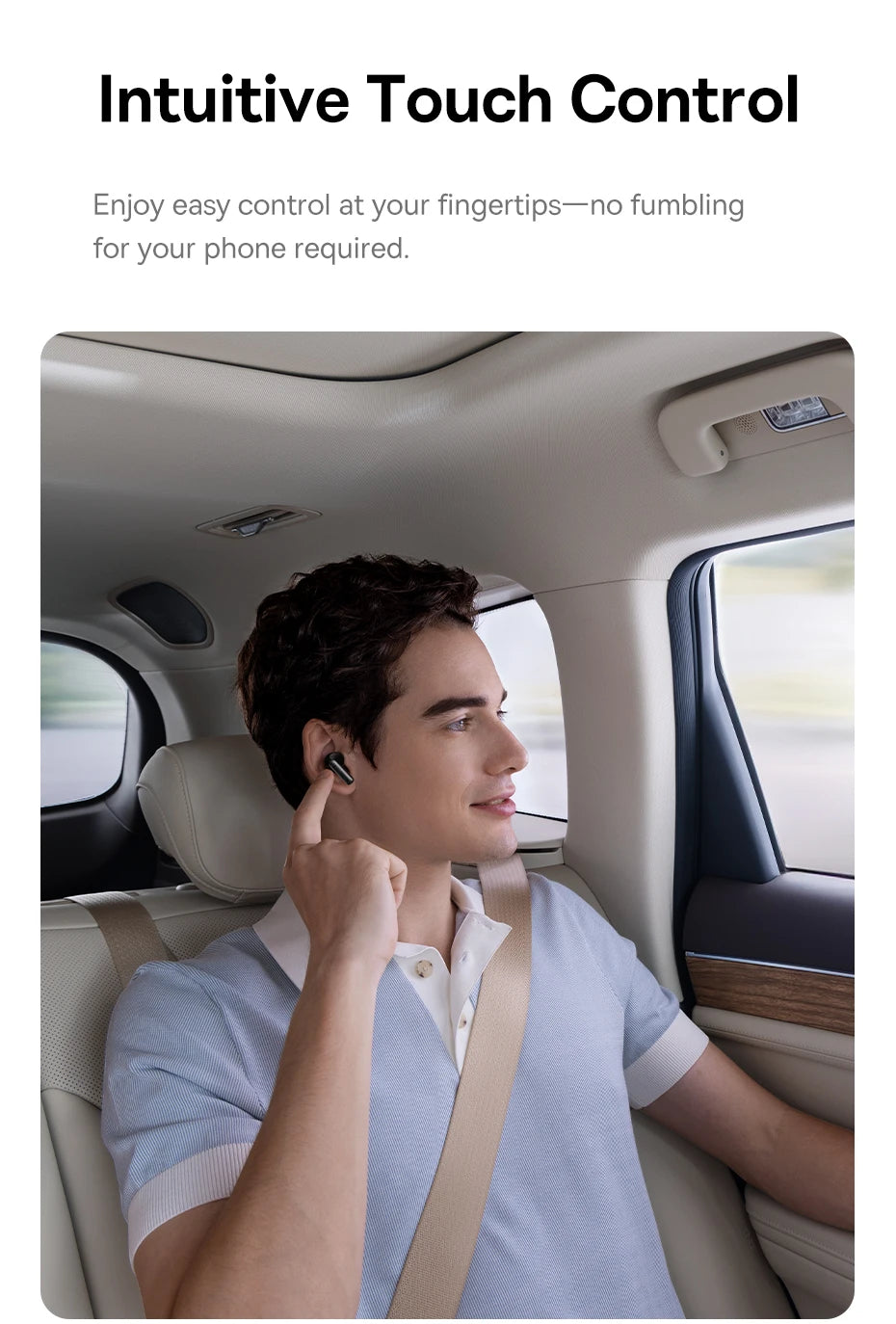 A man in a car touches his sleek, black wireless earbud to control audio settings.
